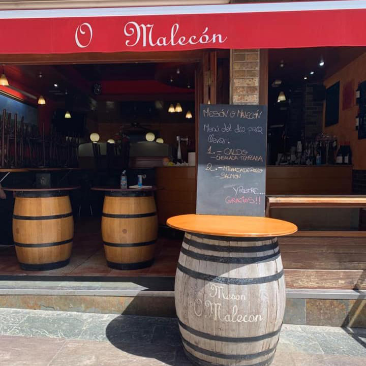 La puerta del mesón en la que se ven más mesas de tipo barril de vino